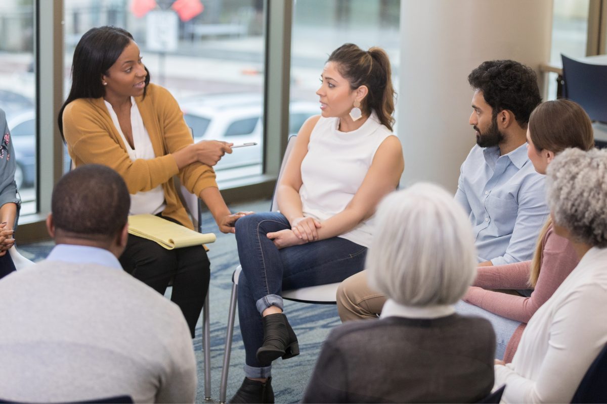 Group therapist facilitating a group therapy session, demonstrating essential group therapist skills such as active listening and guided discussion.