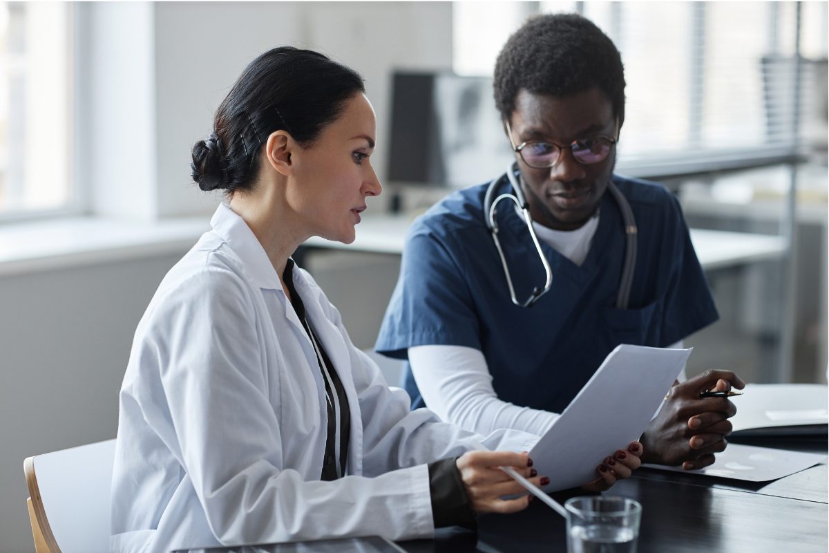 A psychiatrist reviewing a mental health clinical summary with a colleague