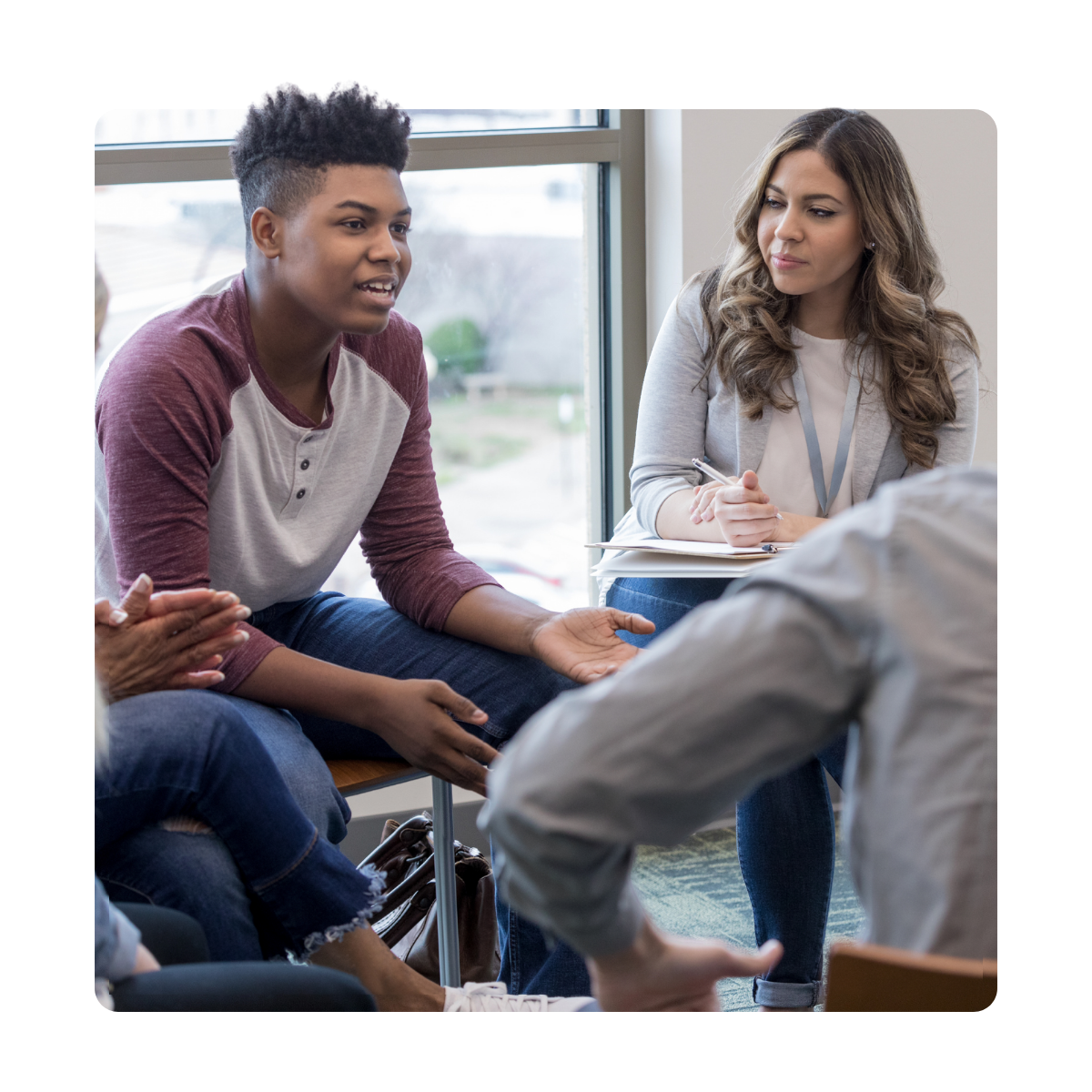 Group therapy session with therapist documenting participant engagement and group progress
